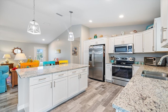 kitchen featuring sink, decorative light fixtures, stainless steel appliances, and white cabinets