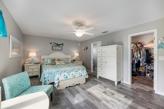 bedroom featuring ceiling fan, wood-type flooring, a spacious closet, and a closet