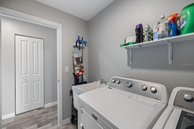 washroom with washing machine and dryer and light hardwood / wood-style flooring