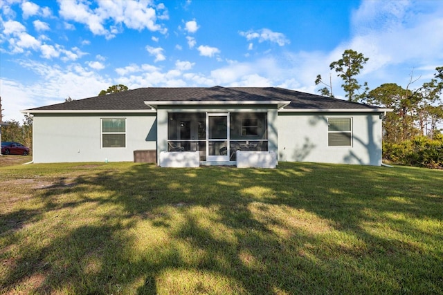 rear view of house with a sunroom and a yard