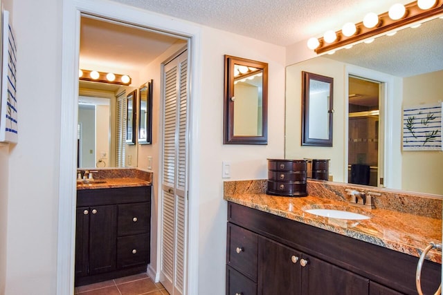 bathroom with vanity, tile patterned flooring, a shower with door, and a textured ceiling