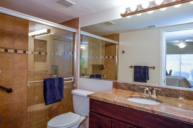 bathroom with vanity, ceiling fan, a shower with door, and toilet