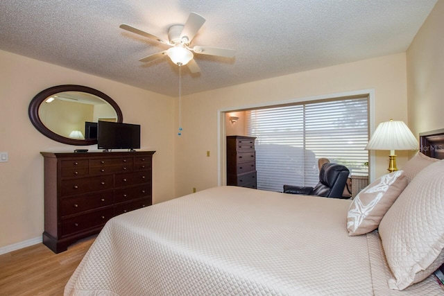 bedroom featuring ceiling fan, light hardwood / wood-style flooring, and a textured ceiling