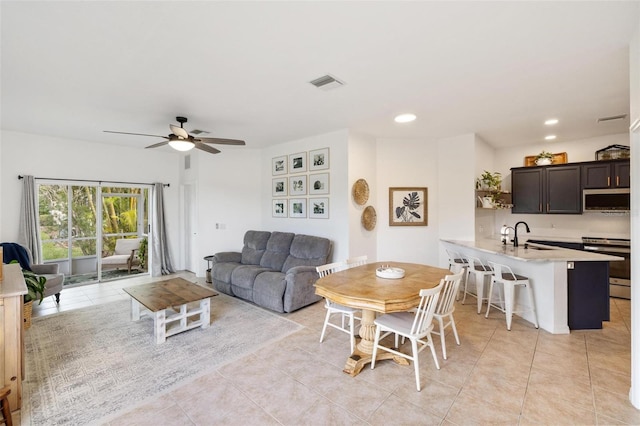 dining area with ceiling fan, sink, and light tile patterned floors