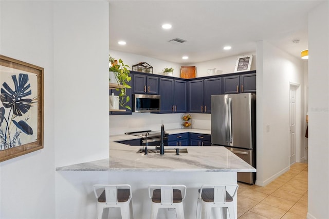 kitchen featuring sink, a breakfast bar area, kitchen peninsula, stainless steel appliances, and blue cabinetry