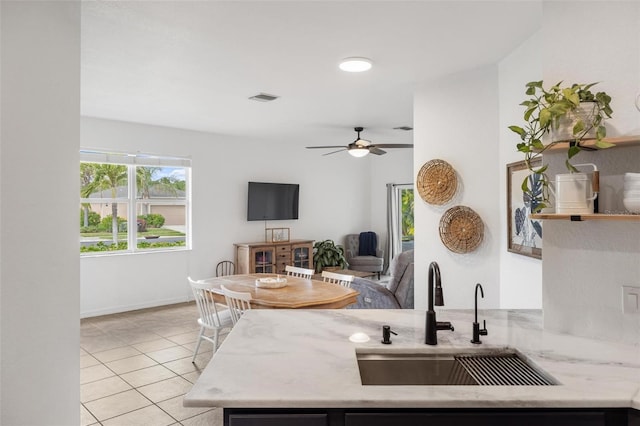 kitchen with sink, light tile patterned floors, kitchen peninsula, and ceiling fan