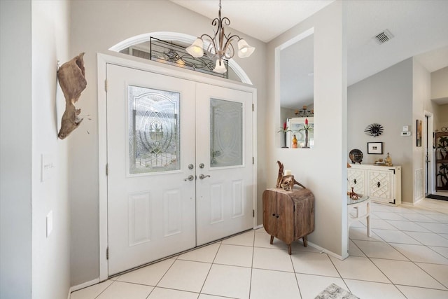 entryway featuring a notable chandelier, french doors, and light tile patterned flooring