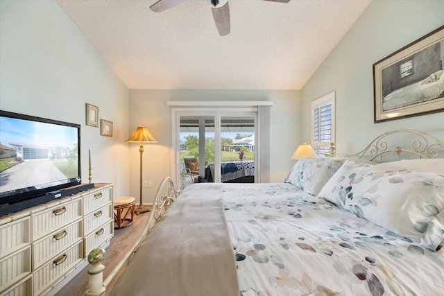 bedroom with lofted ceiling, a textured ceiling, wood-type flooring, and access to outside