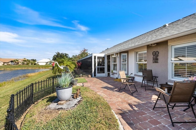 view of patio / terrace with a sunroom and a water view