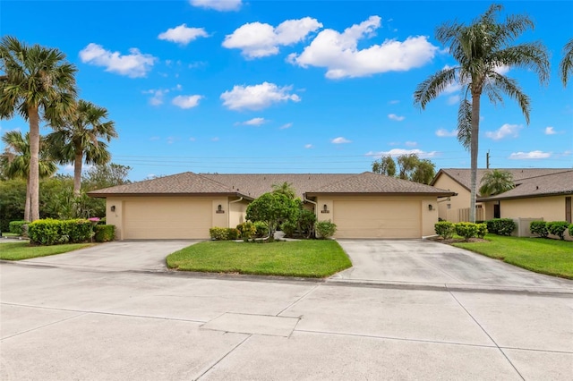 ranch-style house featuring a garage and a front lawn