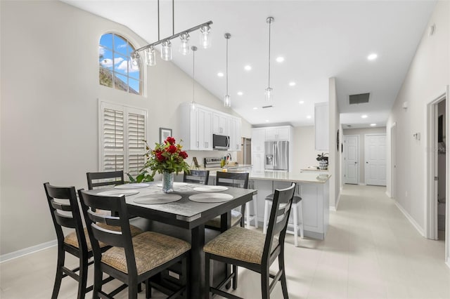 dining space with sink and a high ceiling