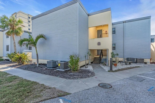 view of side of property featuring cooling unit and a balcony