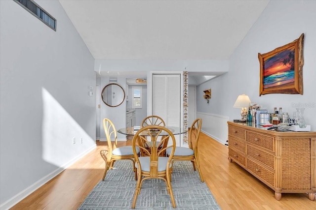 dining space with vaulted ceiling and hardwood / wood-style floors