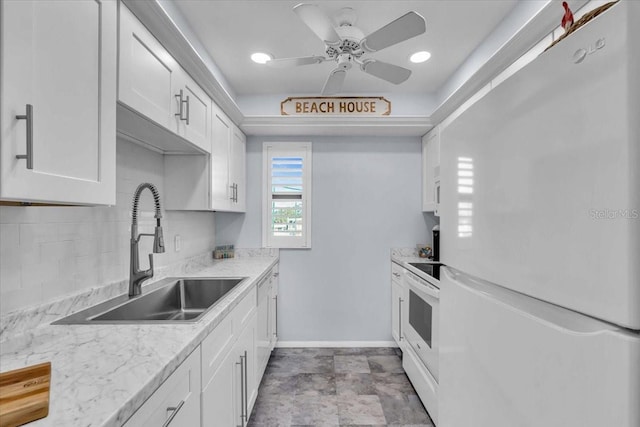 kitchen with tasteful backsplash, sink, white cabinets, light stone countertops, and white appliances