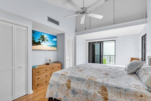 bedroom with light hardwood / wood-style flooring, ceiling fan, high vaulted ceiling, access to outside, and multiple closets