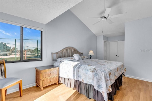 bedroom featuring ceiling fan, vaulted ceiling, hardwood / wood-style floors, and a textured ceiling