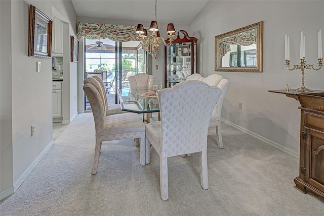 dining space with lofted ceiling, a notable chandelier, and light colored carpet