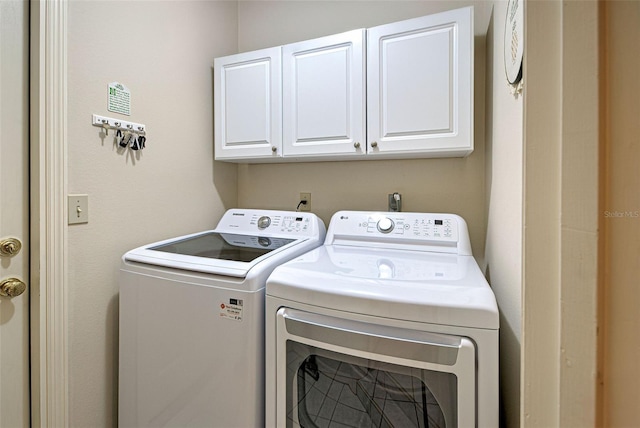 washroom featuring cabinets and washing machine and clothes dryer