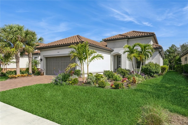 mediterranean / spanish house featuring a garage and a front yard