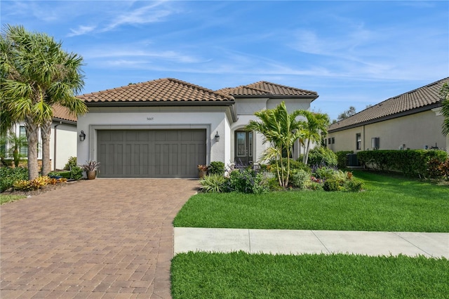 mediterranean / spanish-style house with cooling unit, a garage, and a front yard