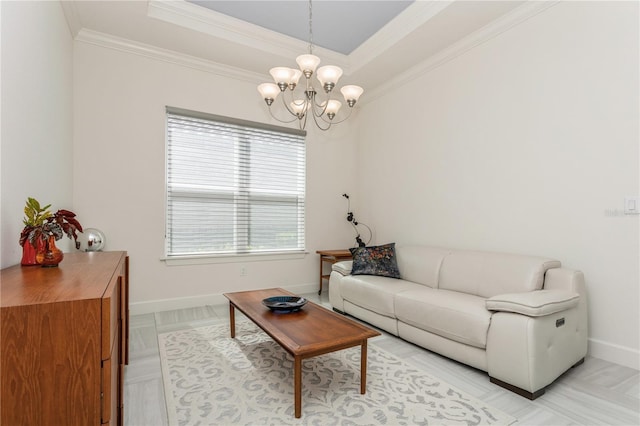 living room with an inviting chandelier, a tray ceiling, and ornamental molding