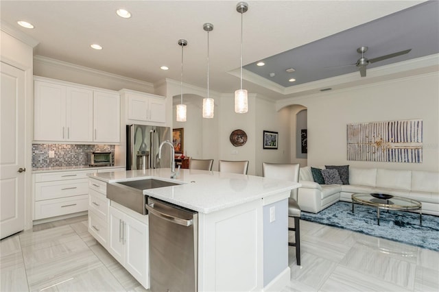 kitchen featuring an island with sink, appliances with stainless steel finishes, sink, and white cabinets