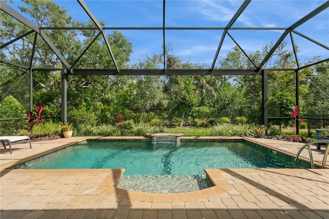 view of pool featuring pool water feature, glass enclosure, and a patio area