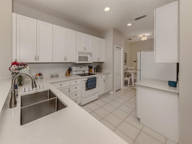 kitchen featuring white cabinetry, sink, and white appliances