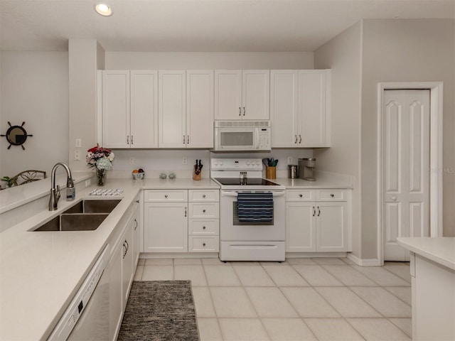 kitchen featuring sink, white appliances, light tile patterned floors, and white cabinets