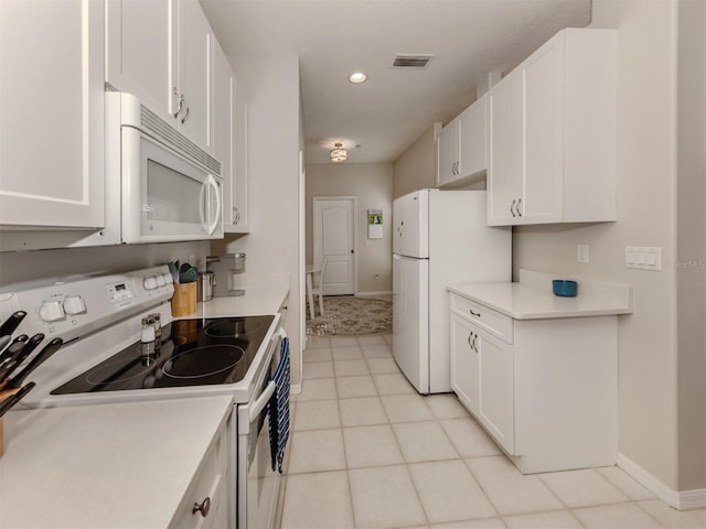 kitchen with light tile patterned flooring, white cabinets, and white appliances