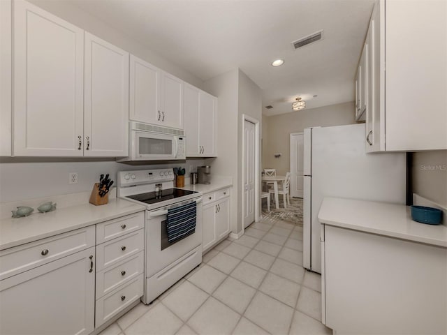 kitchen featuring white cabinetry, light tile patterned floors, and white appliances