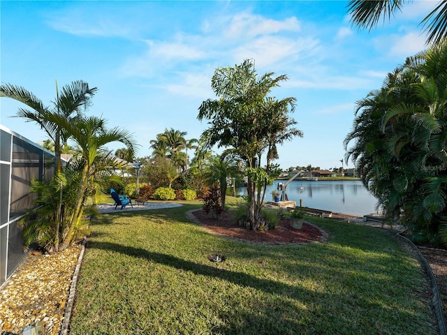 view of yard with a lanai and a water view