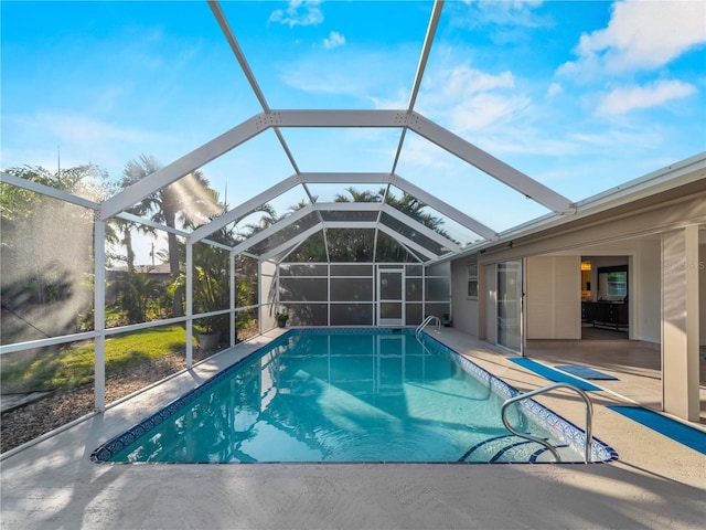 view of pool with a patio and glass enclosure