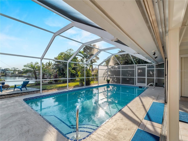 view of pool featuring a lanai, a patio, and a water view