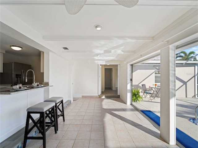 interior space with ceiling fan and exterior bar