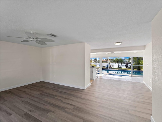 spare room with ceiling fan, hardwood / wood-style floors, and a textured ceiling