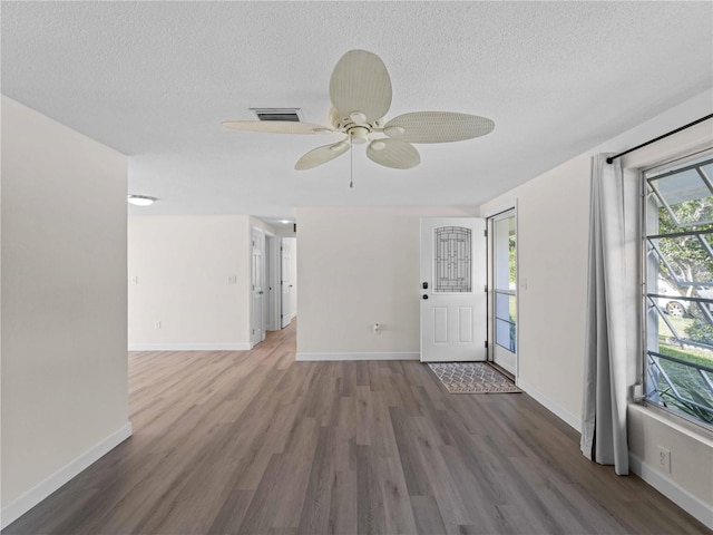 interior space featuring ceiling fan, dark hardwood / wood-style floors, and a textured ceiling