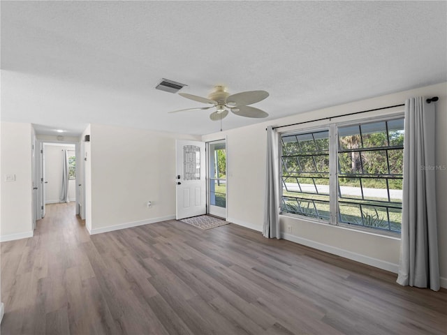 unfurnished room featuring ceiling fan, wood-type flooring, and a textured ceiling