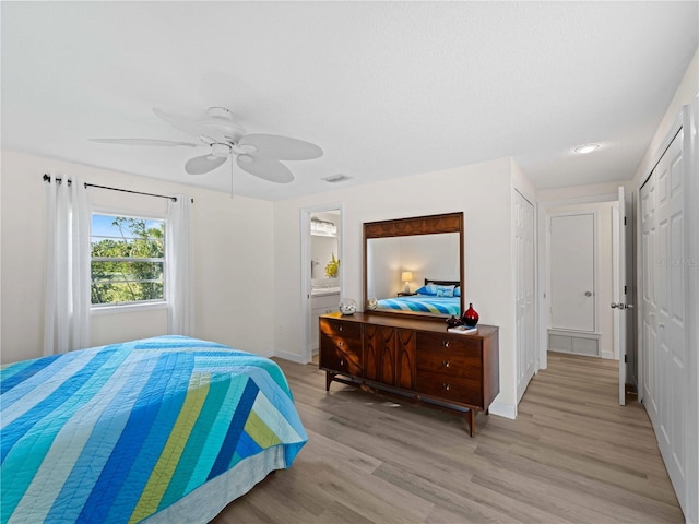 bedroom with ensuite bath, light hardwood / wood-style flooring, and ceiling fan