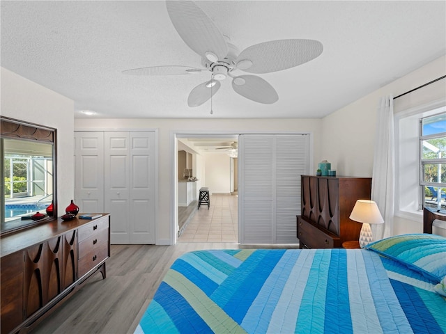 bedroom with ceiling fan, a textured ceiling, and light hardwood / wood-style floors