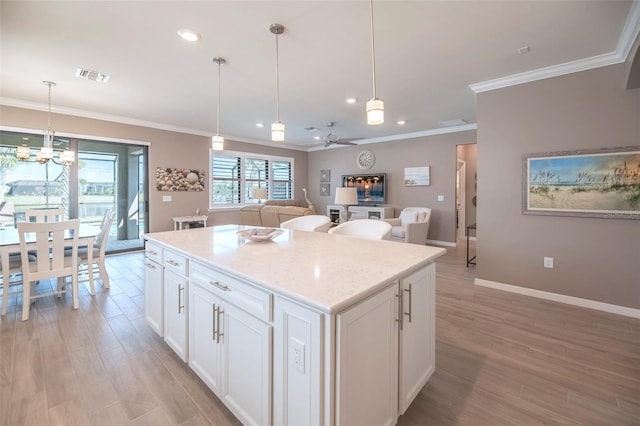 kitchen featuring a center island, pendant lighting, and white cabinets