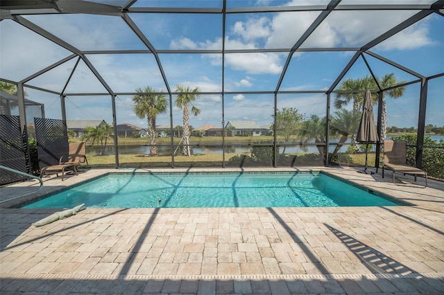 view of pool featuring a patio, a water view, and glass enclosure