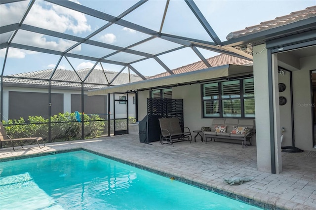 view of swimming pool with glass enclosure and a patio area