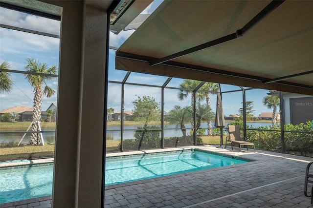 view of swimming pool featuring a water view, a lanai, and a patio area