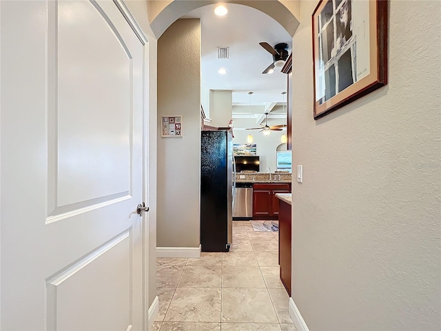 corridor featuring sink and light tile patterned floors