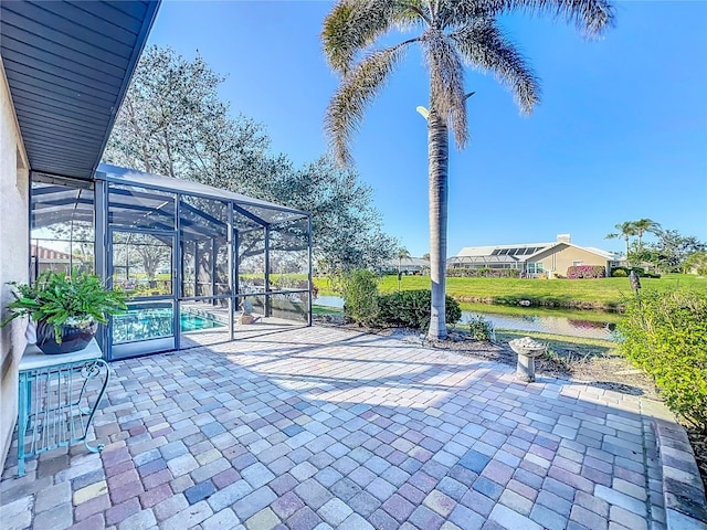 view of patio with a water view and glass enclosure