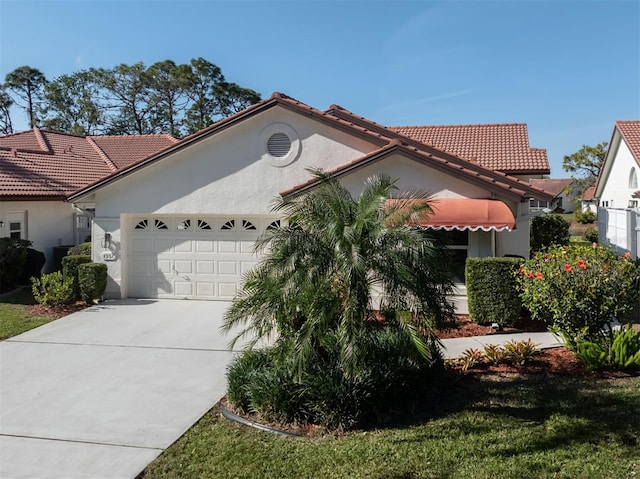 mediterranean / spanish-style home with a garage and a front lawn