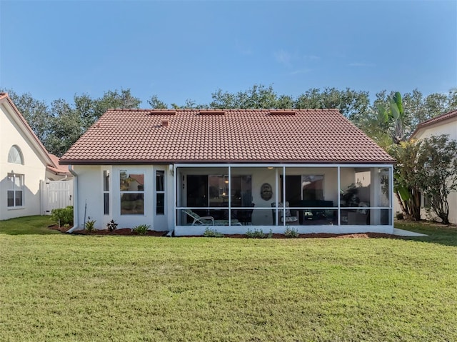 rear view of house with a sunroom and a lawn