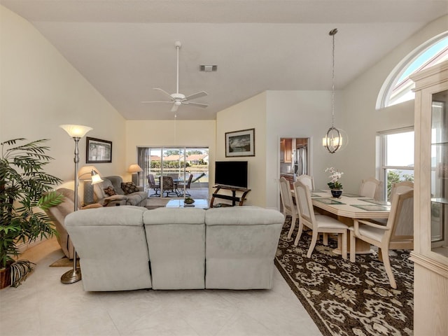 living room with ceiling fan with notable chandelier and high vaulted ceiling