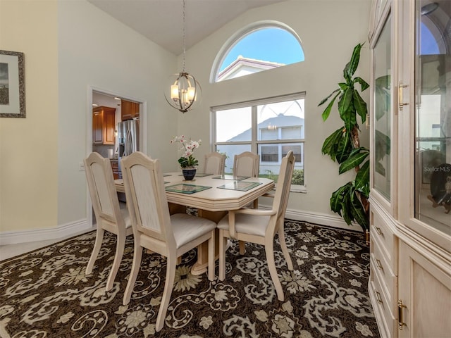 dining area featuring high vaulted ceiling and a chandelier